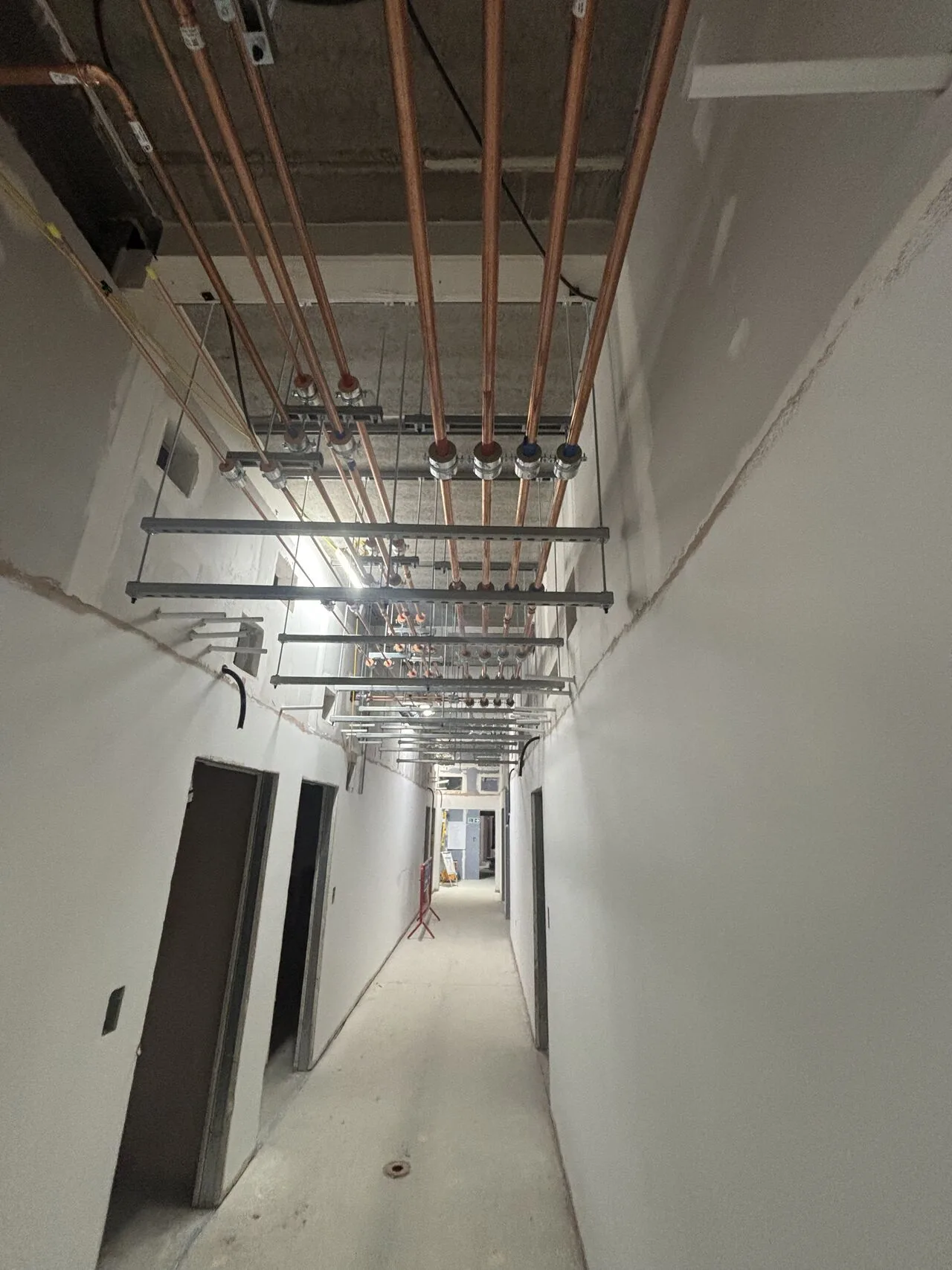 Overhead copper pipework along a commercial corridor: commercial plumbing in Mansfield