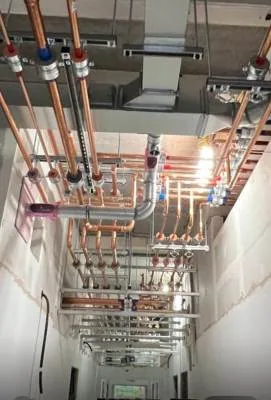 Copper pipework manifolds installed above a corridor ceiling